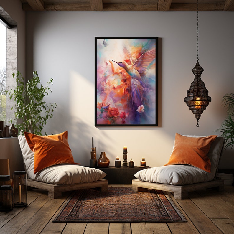 Op de afbeelding: Een ingelijst schilderij van een kleurrijke kolibrie in vlucht tegen een achtergrond van abstracte bloemen en wolken. Het schilderij hangt aan een witte muur in een woonkamer met twee oranje kussens en een houten vloer.