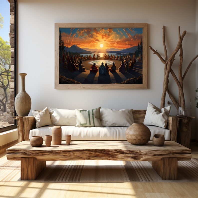 May include: A framed painting depicting a group of people sitting in a circle around a campfire, with a sunset in the background. The painting is hanging on a wall in a living room, with a couch and coffee table in front of it.