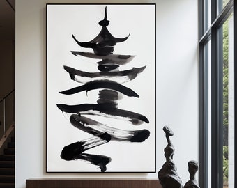 Op de afbeelding: Een abstract zwart-wit schilderij van een pagode met penseelstreken op een witte achtergrond. Het schilderij hangt aan een muur in een modern interieur met een houten bank en een zwarte salontafel met een sculptuur erop.