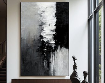 Könnte beinhalten: Ein abstraktes Schwarzweißbild hängt an einer weißen Wand in einem modernen Wohnzimmer. Das Bild ist in zwei Abschnitte unterteilt, einen schwarzen und einen weißen, mit einem grauen Bereich in der Mitte. Das Bild ist in einem schwarzen Rahmen gerahmt. Der Raum hat einen Holzboden und eine Holzbank vor dem Bild. Auf der rechten Seite des Bildes befindet sich ein großes Fenster, und vor dem Fenster steht eine Skulptur auf einem Holztisch.