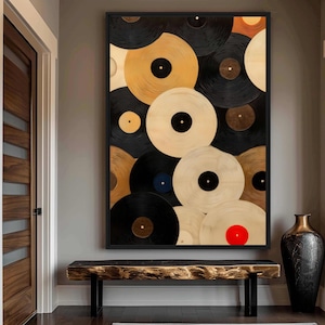 May include: A framed artwork displaying a collage of vinyl records in black, gold, and cream. The records overlap, creating a textured effect. A red record provides a focal point. The artwork is a striking piece of wall decor.