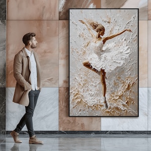 May include: A framed painting of a ballerina in a white tutu, dancing on a textured background of gold and white. The ballerina is in mid-air, with her arms outstretched and her legs extended.