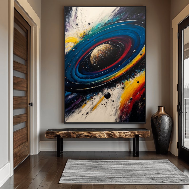 May include: A colorful abstract painting of a galaxy with a large planet in the center surrounded by rings. The painting is framed in black and hanging on a wall in a hallway.