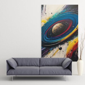 May include: Abstract painting of a colorful galaxy with a planet in the center. The galaxy is surrounded by a ring of stars and planets. The painting is on a white canvas and is framed in a black frame.