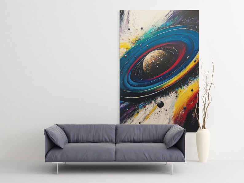 May include: Abstract painting of a colorful galaxy with a planet in the center. The galaxy is surrounded by a ring of stars and planets. The painting is on a white canvas and is framed in a black frame.