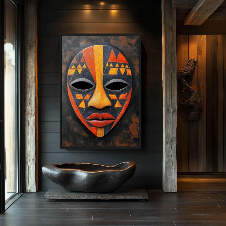May include: A large, framed African mask with a black background. The mask features a face with orange, yellow, and red geometric patterns. Below the mask is a dark, organic-shaped sculpture on a stone base.