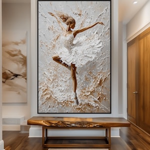 May include: A white ballerina in a white tutu is dancing in a swirl of white and gold paint. The painting is framed in black.