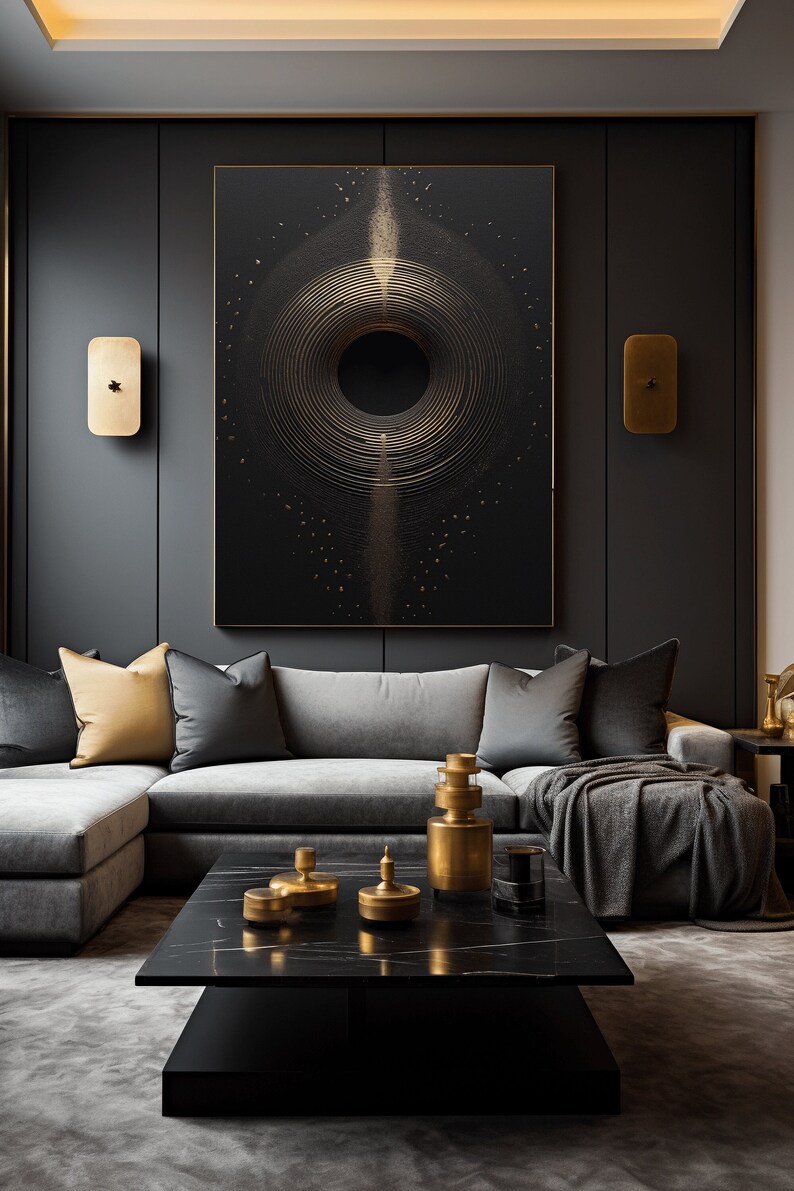 Puede incluir: Un sal&oacute;n moderno con una gran obra de arte abstracta en oro y negro, con c&iacute;rculos conc&eacute;ntricos. La habitaci&oacute;n incluye un sof&aacute; seccional gris, una mesa de centro de m&aacute;rmol negro y detalles dorados, creando un ambiente lujoso.