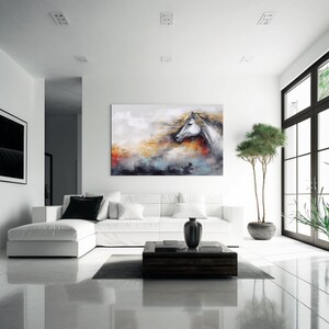 May include: White horse head painting with a colourful abstract background. The painting is hanging on a white wall in a modern living room with a white sectional sofa and a coffee table.