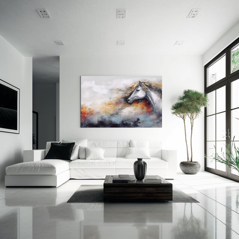 May include: White horse head painting with a colourful abstract background. The painting is hanging on a white wall in a modern living room with a white sectional sofa and a coffee table.