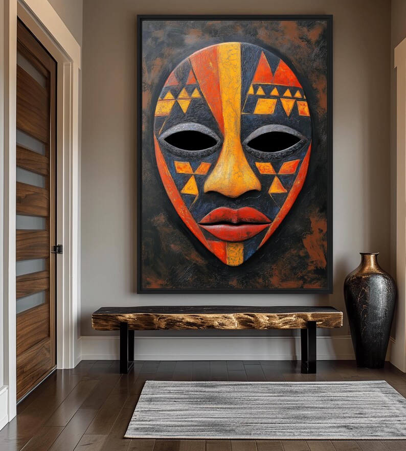 May include: A large, framed African mask with a black background. The mask features a yellow nose, red lips, and a design of orange, yellow, and blue triangles. The mask is hanging above a wooden bench and a decorative vase.