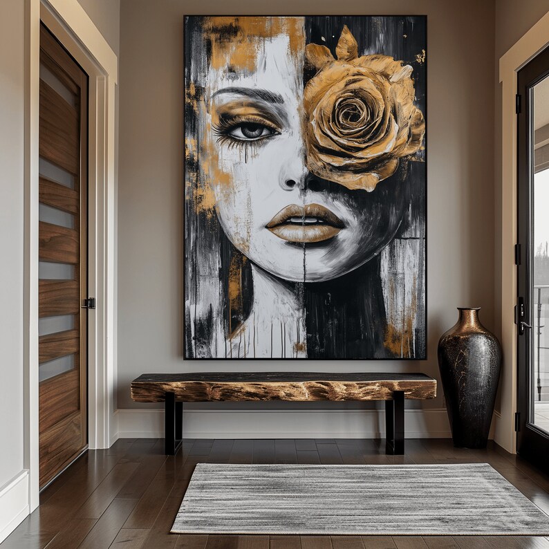 May include: Abstract painting of a woman's face with a large golden rose covering one eye. The painting is in a black frame and is hanging on a wall above a wooden bench.