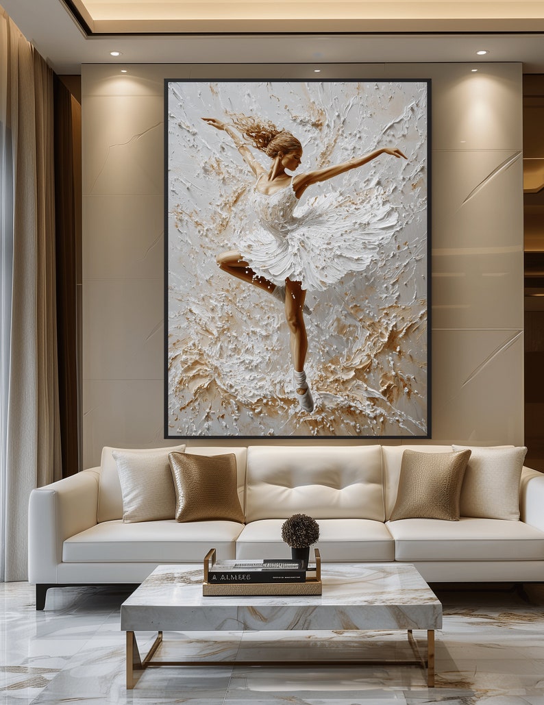 May include: A white canvas painting of a ballerina in a white tutu, dancing on a white background with gold accents. The painting is framed in a black frame.