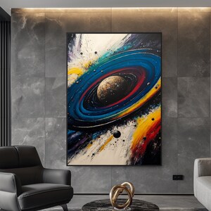 May include: Abstract painting of a colorful galaxy with a planet in the center. The galaxy is surrounded by a ring of stars and planets. The painting is done in a variety of colors, including blue, green, yellow, and red.