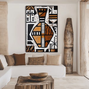 May include: Abstract geometric art print featuring a stylized vase in shades of brown, black, and white. The print is framed and hanging on a white wall in a modern living room setting.