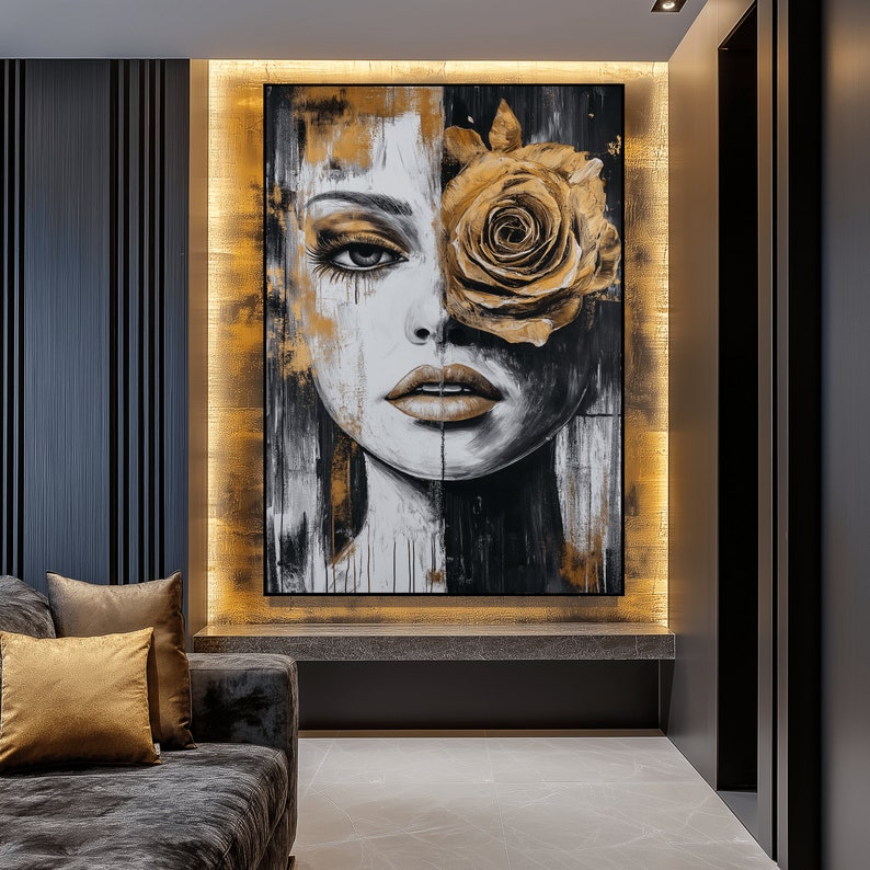 May include: A black and white painting of a woman's face with a large golden rose covering one eye. The background is a textured gold.