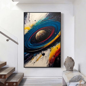 May include: Abstract painting of a colorful galaxy with a planet in the center. The galaxy is painted in shades of blue, yellow, red, and white. The planet is a dark gray color with a textured surface.