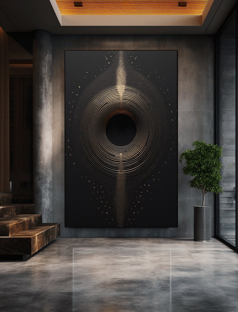 Puede incluir: Gran obra de arte abstracta en negro y dorado con c&iacute;rculos conc&eacute;ntricos y un vac&iacute;o central. La obra se exhibe en un interior moderno con una planta en maceta y una escalera.