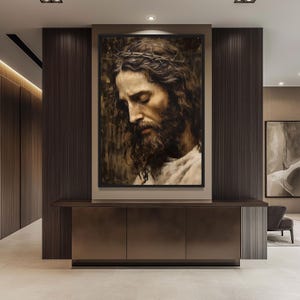 May include: A framed painting of a man with a crown of thorns, looking down with his eyes closed. The painting is in a dark brown frame and is hanging on a wall.