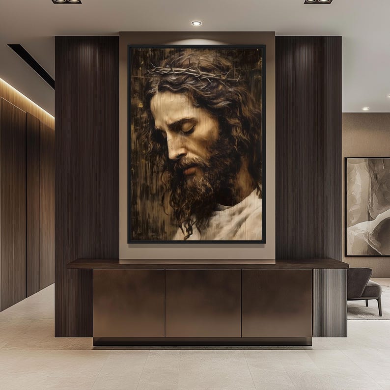 May include: A framed painting of a man with a crown of thorns, looking down with his eyes closed. The painting is in a dark brown frame and is hanging on a wall.