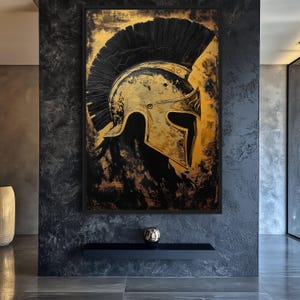 Op de afbeelding: Een gouden en zwarte schildering van een Spartaanse helm met een zwarte pluim. De helm is in profiel afgebeeld, met de pluim die naar rechts uitsteekt. De achtergrond is een getextureerd zwart en goud.