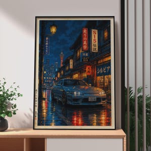 May include: A framed art print depicting a silver Nissan Silvia S15 parked on a wet city street at night. The scene features Japanese neon signs, a distant tower, and reflections of warm and cool lights on the pavement. The text includes S15, Silvia, and Japanese characters.