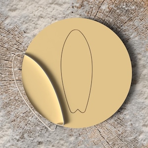 Op de afbeelding: Een beige sticker met een surfboard-omtrek. De sticker is rond met een gebogen rand die is losgetrokken en een witte kleeflaag onthult. De achtergrond is een getextureerd, lichtbruin houten oppervlak.