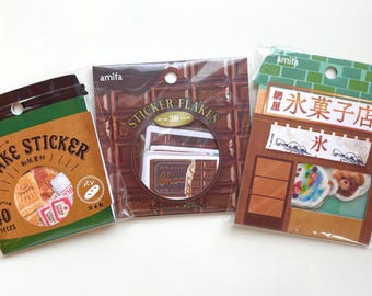 May include: Three packs of decorative stickers. One pack is brown and green with "FLAKE STICKER" text and contains 40 pieces. Another is brown with "STICKER FLAKES" text and 30 pieces. The last is a shop design with Japanese text.