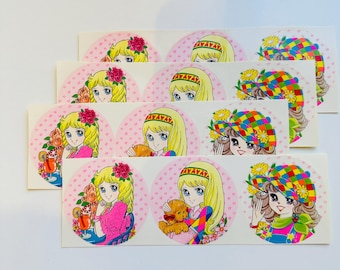 Puede incluir: Hojas de pegatinas con una ilustración de estilo anime vintage de una joven con cabello rubio. Las pegatinas tienen un fondo rosa con lunares. Algunas pegatinas muestran a la mujer con flores, un osito de peluche o un sombrero colorido.