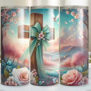 Op de afbeelding: Een sublimatiebeker met een kleurrijk ontwerp met een houten kruis met een turquoise lint en een duif die erboven vliegt. De achtergrond is een pastelkleurig landschap met roze en blauwe bloemen.