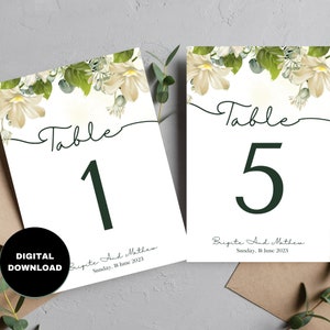 May include: Two white table number cards with green floral designs and calligraphy. The cards are for a wedding and say "Table 1" and "Table 5". The text also includes the names "Brigite and Mathew" and the date "Sunday, 18 June 2023".