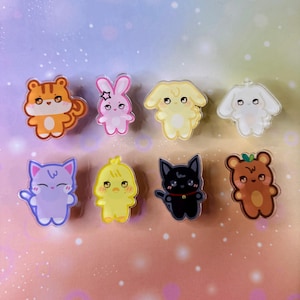 Puede incluir: Ocho pines de personajes de dibujos animados de animales coloridos. Los pines están hechos de acrílico transparente con un diseño impreso. Los personajes incluyen un tigre, un conejito, un perro, un gato, un pollito, un oso y dos perros más.