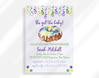 May include: A baby shower invitation with a purple, green, and yellow cake with white icing. The invitation says "She got the baby!" and includes the details for the shower, including the date, time, location, and contact information for regrets.