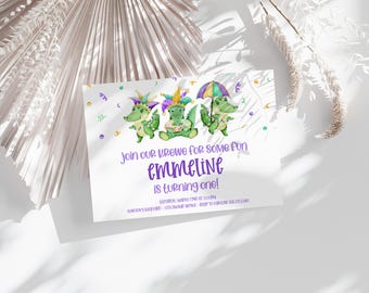 May include: A white invitation card with a purple and green alligator theme. The text reads "Join our krewe for some fun Emmeline is turning one!"