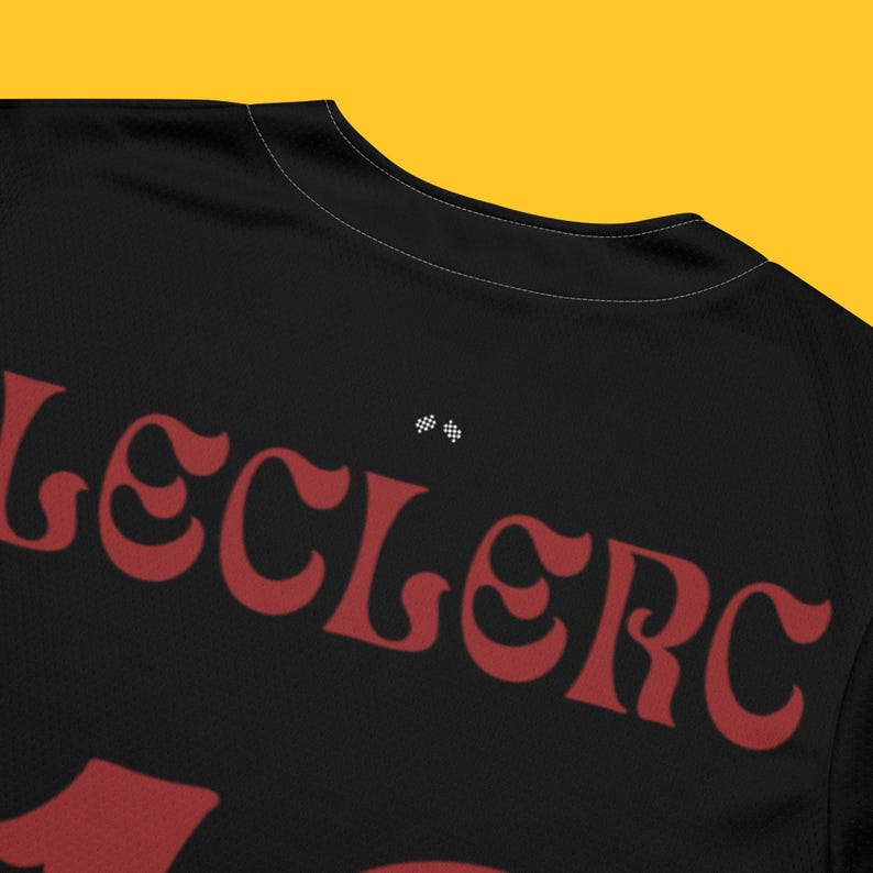 May include: Black t-shirt with a red "Leclerc" name and racing flag design on the back.