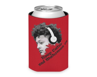 May include: Red can cooler with a black and white image of a person wearing headphones. The text "Keep Calm and Mahomes on" is printed on the cooler.