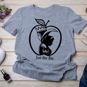 May include: A grey t-shirt featuring a black silhouette of the Evil Queen and Snow White within an apple. The text "Just One Bite" is printed beneath the apple.