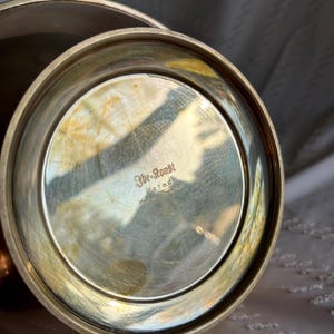 May include: The bottom of a silver bowl with the inscription "3br-Ronsh Ystad Made in Sweden".