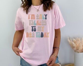 May include: Pink t-shirt with the text "I'm only talking to my dog today" in a colourful retro font.