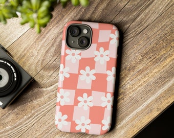 Puede incluir: Una funda de teléfono rosa y blanca con un patrón a cuadros y flores blancas. La funda está diseñada para un iPhone.