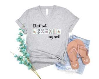 May include: Gray V-neck t-shirt with the text "Check out my rack" and a graphic of Mahjong tiles.