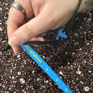 May include: A white ceramic mug with a black handle and the text "But First, Coffee" in a black, bold font. The mug is on a white surface.