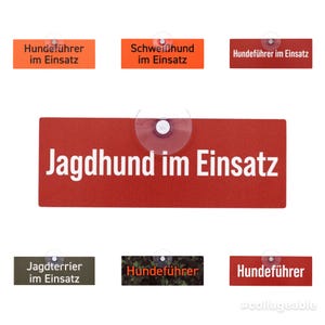Könnte beinhalten: Eine Sammlung rechteckiger Schilder mit weißem Text auf verschiedenen farbigen Hintergründen. Die Schilder enthalten Sätze wie "Hundeführer im Einsatz" und "Jagdhund im Einsatz". Jedes Schild hat einen Saugnapf.
