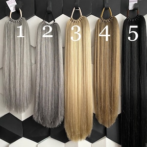 May include: Five different colored hair extensions with numbers 1 through 5 labeled on them. The extensions are all the same length and are hanging from a wall.