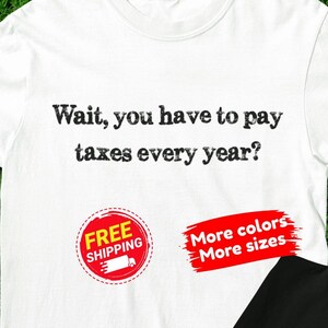 Può includere: Due magliette, una bianca e una nera, con la scritta "Wait, you have to pay taxes every year?". L'immagine include anche un adesivo "Free Shipping" e un adesivo "More colors, More sizes".