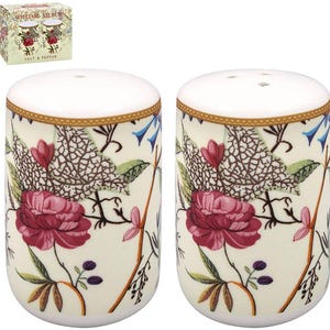 Peut inclure: Deux salières et poivrières en céramique avec un motif floral. Les salières et poivrières ont des dessus blancs et une base crème. Le motif floral comprend des pivoines bordeaux, des campanules bleues et des feuilles vertes. La boîte indique "WILLIAM KILBURN" et "SALT & PEPPER."