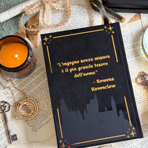 May include: A black book with gold accents and the quote "L'ingegno senza misura &egrave; il pi&ugrave; grande tesoro dell'uomo" by Rowena Ravenclaw. The book features a castle silhouette and star designs, with a lit candle and vintage accessories.