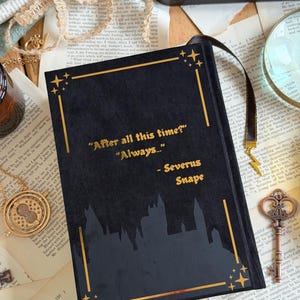 May include: Black journal with gold accents and the quote "After all this time? Always..." by Severus Snape. The cover features a silhouette of a castle. A black ribbon bookmark is attached.