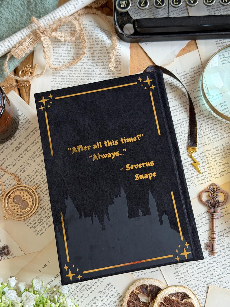 May include: Black journal with gold accents and the quote "After all this time? Always..." by Severus Snape. The cover features a silhouette of a castle. A black ribbon bookmark is attached.