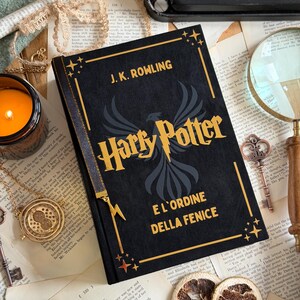 May include: A black hardcover book titled "Harry Potter and the Order of the Phoenix" by J.K. Rowling. The book features gold lettering and a phoenix illustration. The image includes a candle, a magnifying glass, and vintage keys.